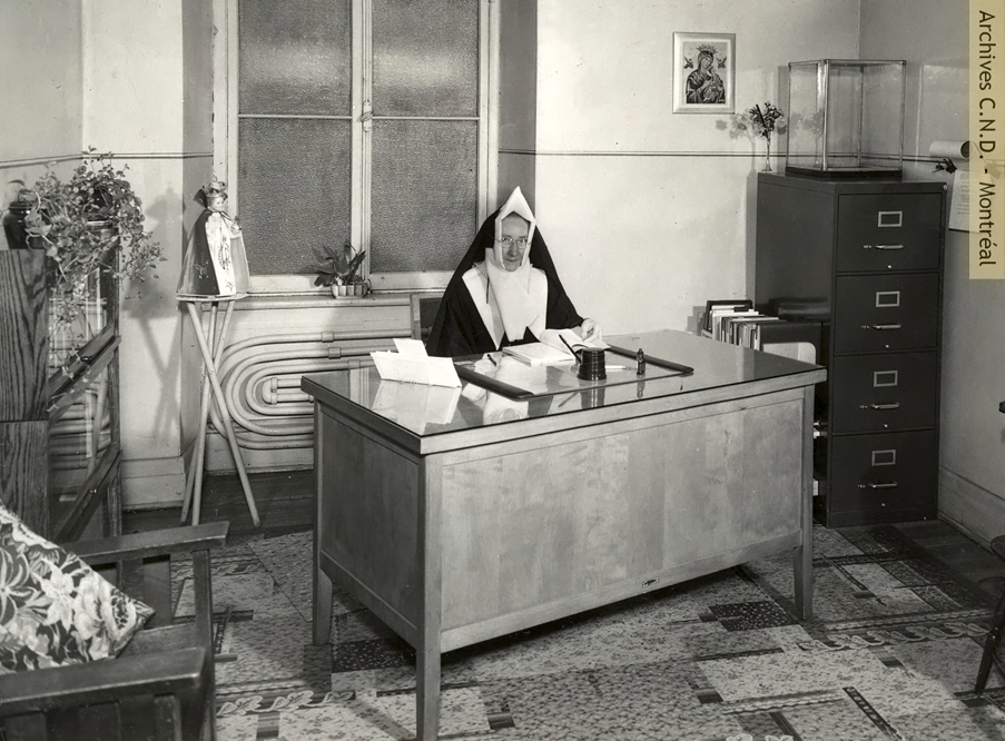 Sœur Sainte-Augustina (Lillian Chafe), supérieure de la Saint Ann Academy, à son bureau